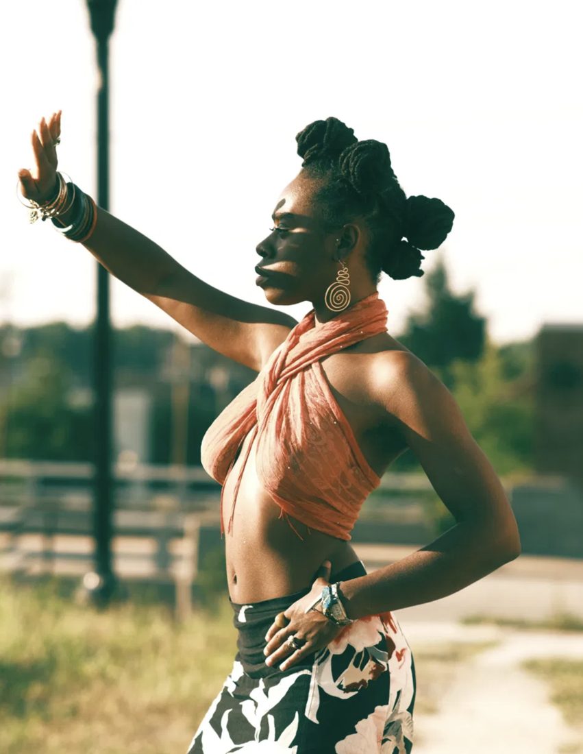 Color photograph in golden hour light, figure with arm raised